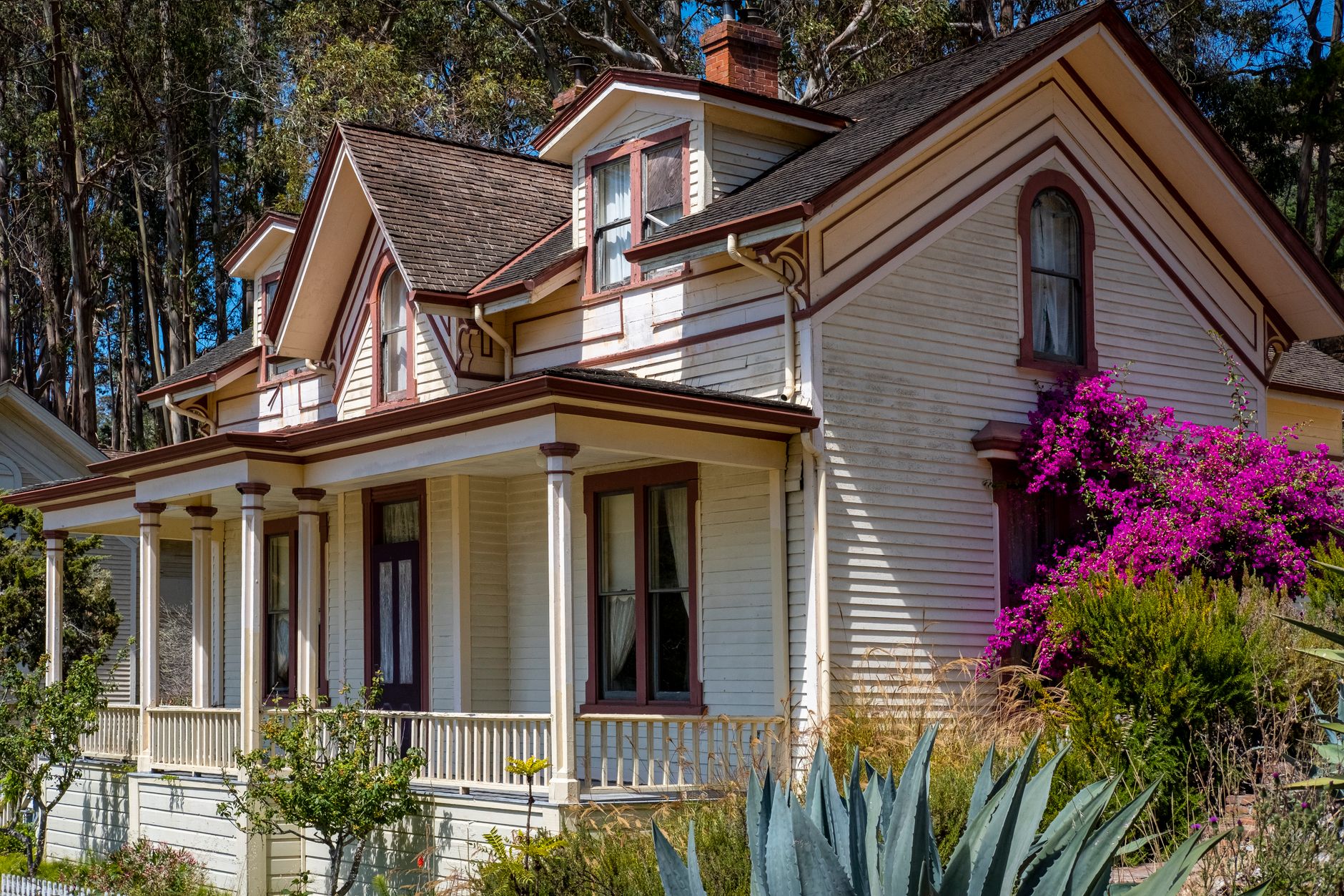 Beautiful Victorian house surrounded by vibrant gardens and trees, perfect for architecture and nature lovers